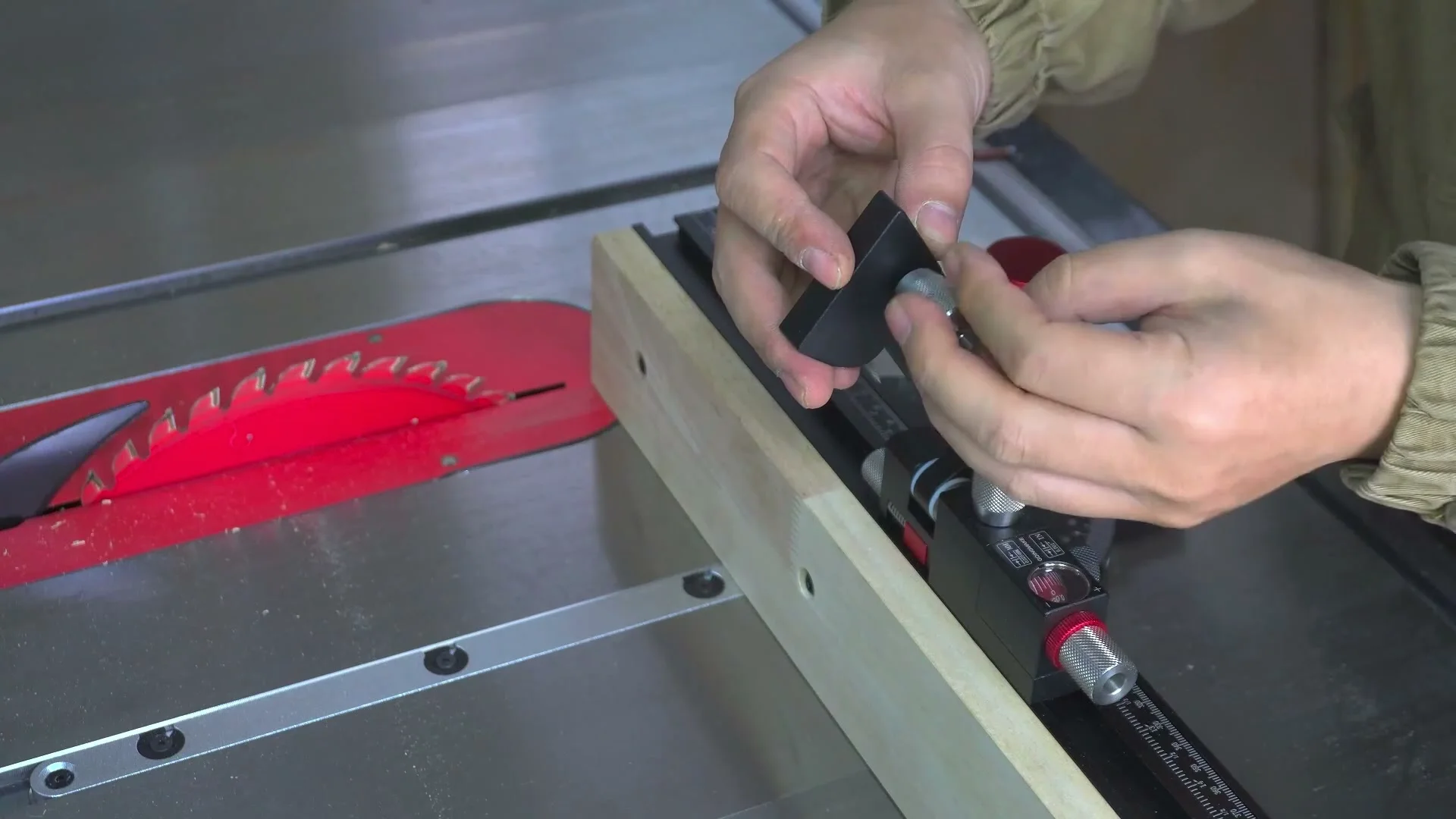 A hand setting the flip stop on the long telescoping fence of a GOINGMAKE miter gauge.